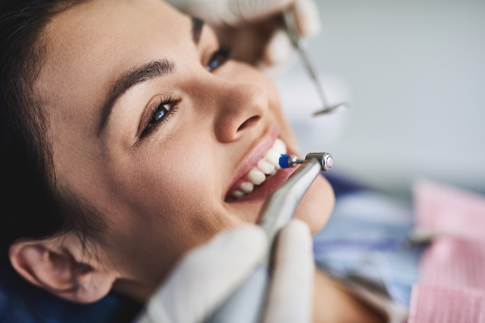 Eine junge Dame bei der professionellen Zahnreinigung in einer Zahnarztpraxis in Berlin