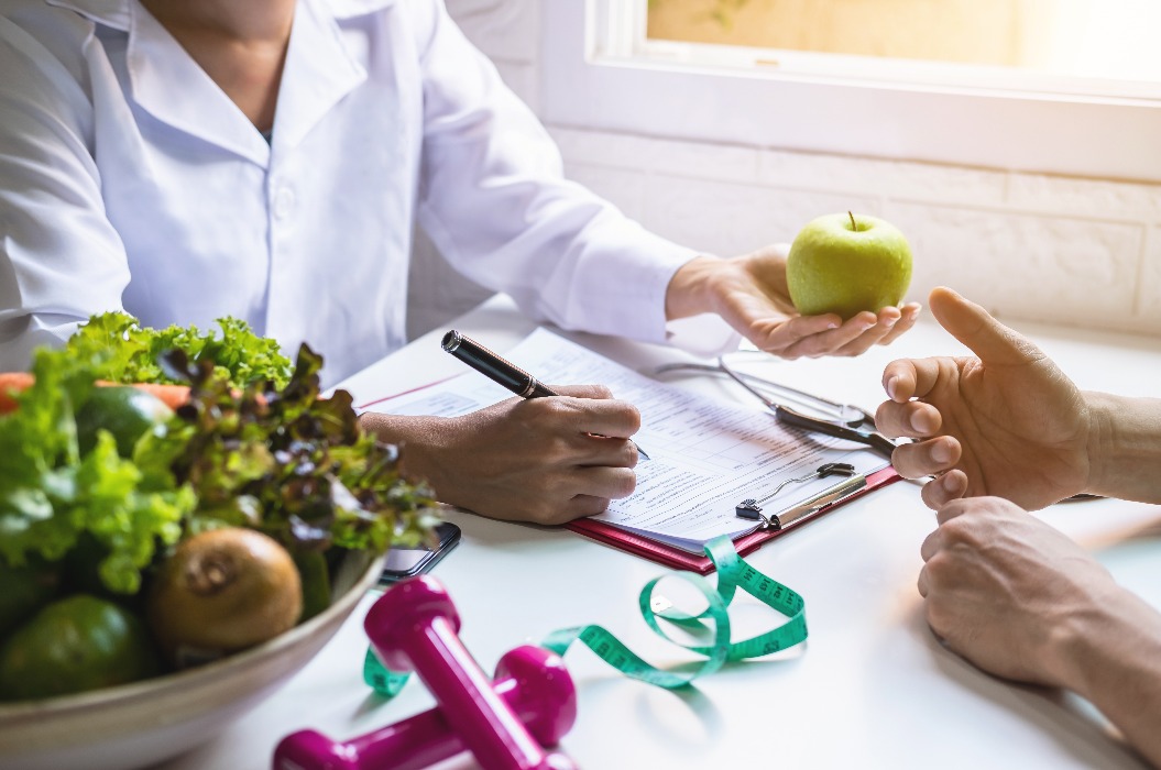 Ernährungsberaterin bei der Beratung eines Patienten mit gesundem Obst und Gemüse, Richtige Ernährung und Diätkonzept